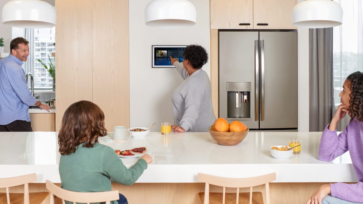 семья за завтраком в кухне с холодильником и планшетом Alexa+