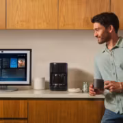 Amazon расширила доступ к Alexa+ в Австралии и назвала цену для не-Prime 1 Мужчина держит кофейную кружку возле компьютера Alexa