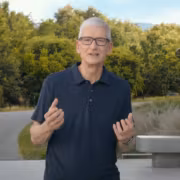 Мужчина в черной рубашке говорит за микрофоном Apple