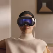 Женщина в белом платье и VR-шлеме Apple Vision Pro