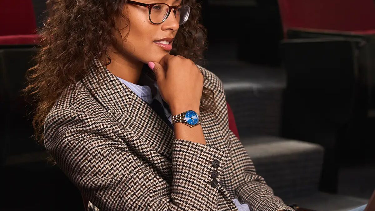 женщина с curly волосами в очках и костюме Citizen Eco-Drive Peyten