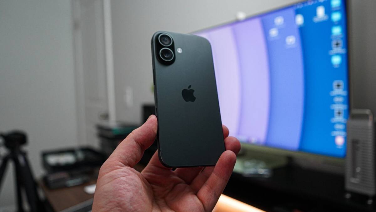 Смартфон iPhone 14 на фоне компьютера с экраном