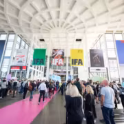IFA 2026 в Берлине покажет, как ИИ уже живет в домах 1 Группа людей в зале конференции или выставки с рекламными баннерами