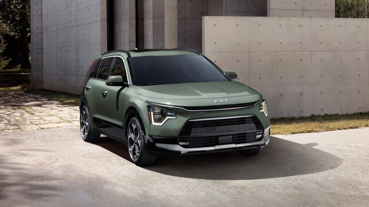 Мятный зеленый Kia Niro 2027 на улице с бетонной стеной