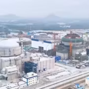 Кран и здания на стройке у реактора Хуалун-1