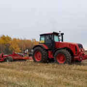трактор МТЗ с сельскохозяйственным оборудованием на поле