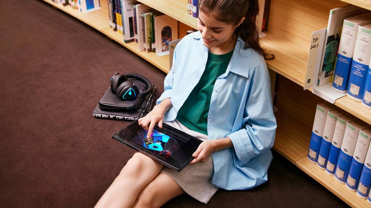 На отдельных ноутбуках ASUS дают 3 месяца Google AI Pro или AI Plus бесплатно 3 девушка сидит на полу в библиотеке с планшетом ASUS Год AI