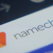 Экран смартфона с логотипом Namecheap и графиком ползучего роста
