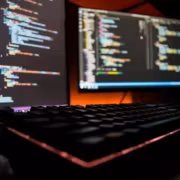 OpenAI приостановила разработку модели Astra после оценки рисков кибербезопасности 3 Два монитора с кодом Astra и клавиатура в темной комнате