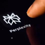 Пальец касается экрана смартфона с логотипом Perplexity