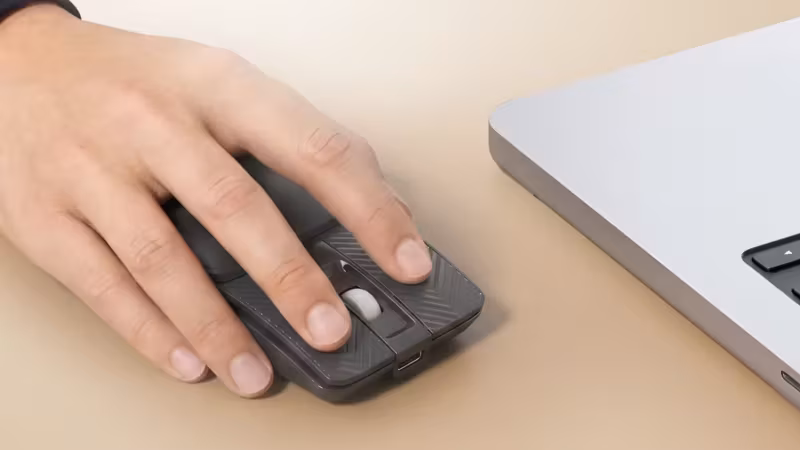 Мышь Portronics Toad Fold рядом с ноутбуком на столе