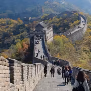 Вид на крепостную стену на фоне леса с туристами