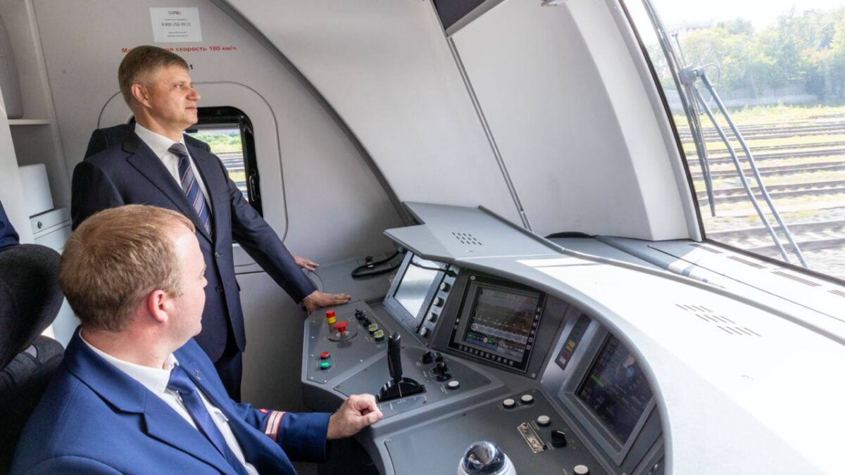 Два мужчины в костюмах в кабине беспилотного поезда РЖД