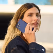 Женщина с длинными светлыми волосами держит смартфон Fairphone 6+ в руке