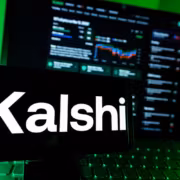 Суд в Вашингтоне обязал Kalshi свернуть большую часть операций в штате 1 Телефон с логотипом Kalshi и экранам трейдинга ноутбука