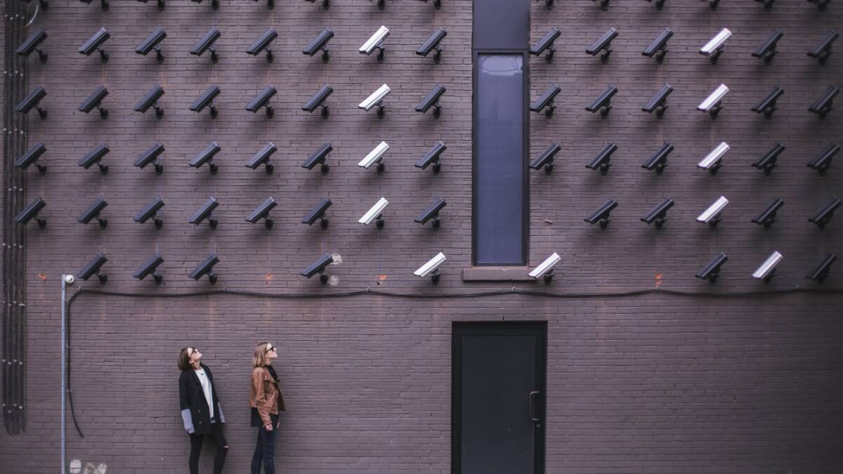 Техасские власти искали через камеры Flock женщину, сделавшую аборт 3 Камеры Flock на кирпичной стене, два человека идут