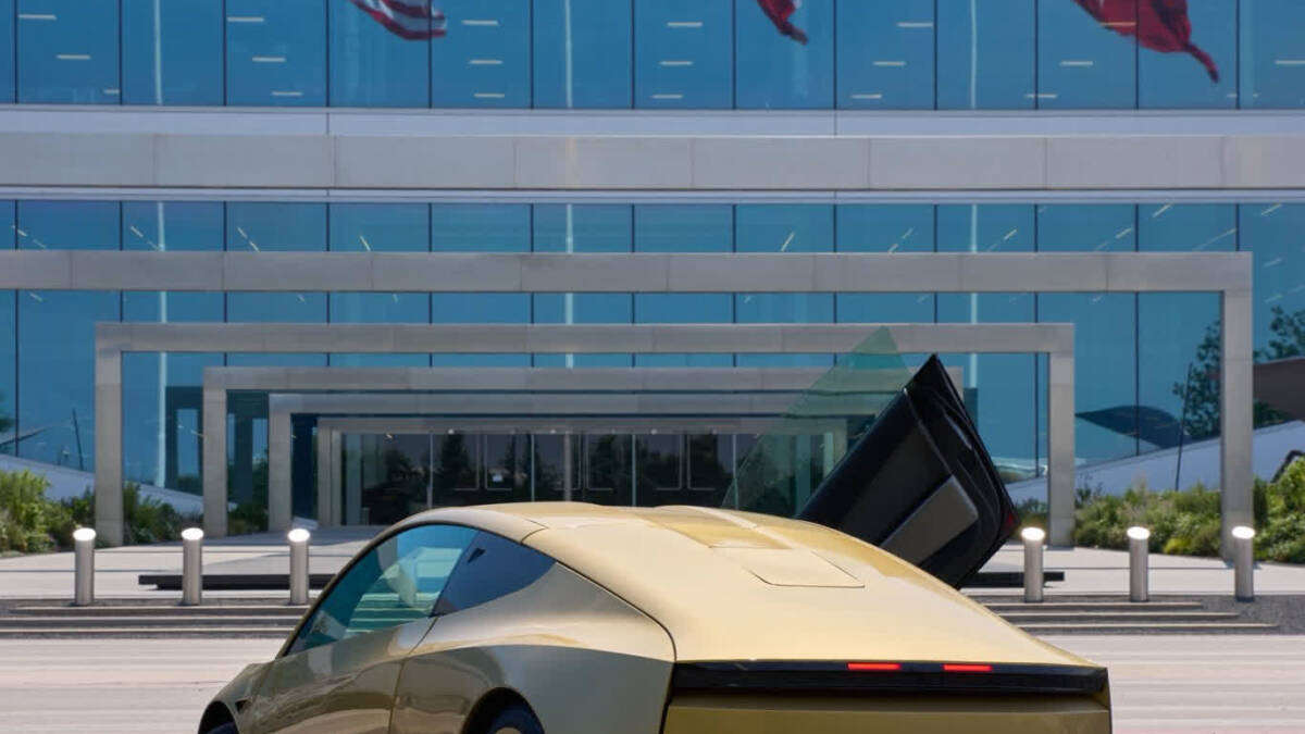 Tesla Cybercab на улице возле здания со стеклянными окнами