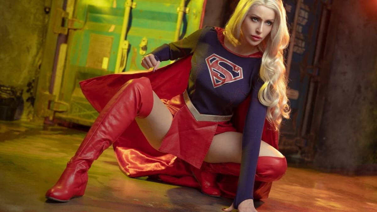 девушка в костюме супергерл из DC на полу