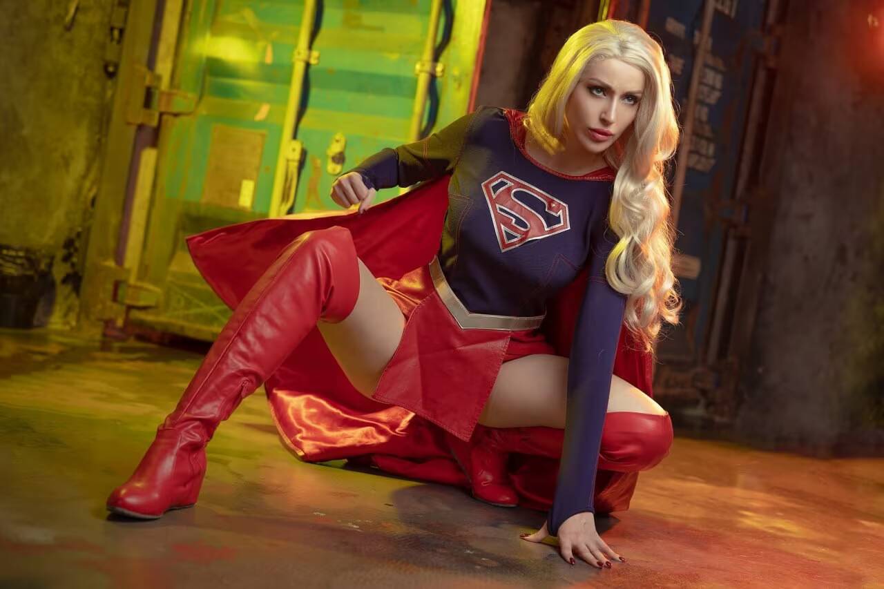 девушка в костюме супергерл из DC на полу
