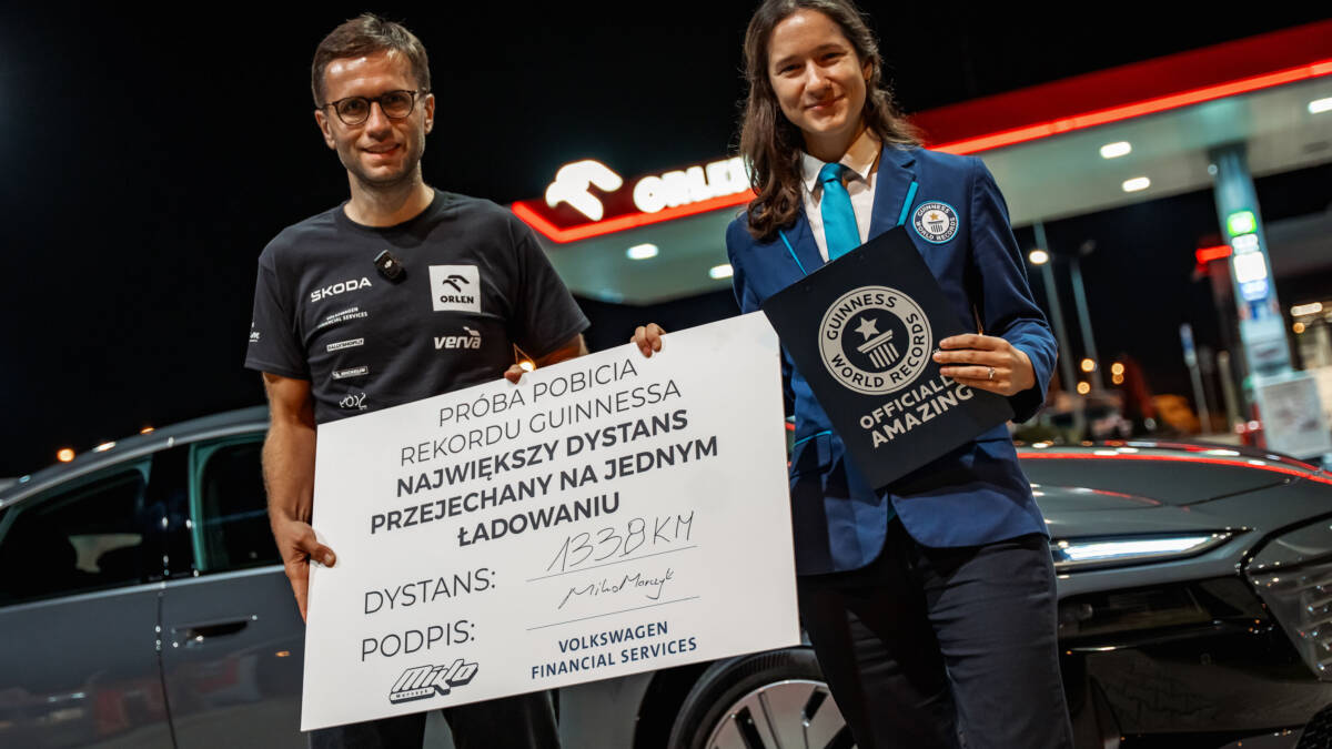 Два человека держат сертификат рекорда Audi A6 Sportback e-tron