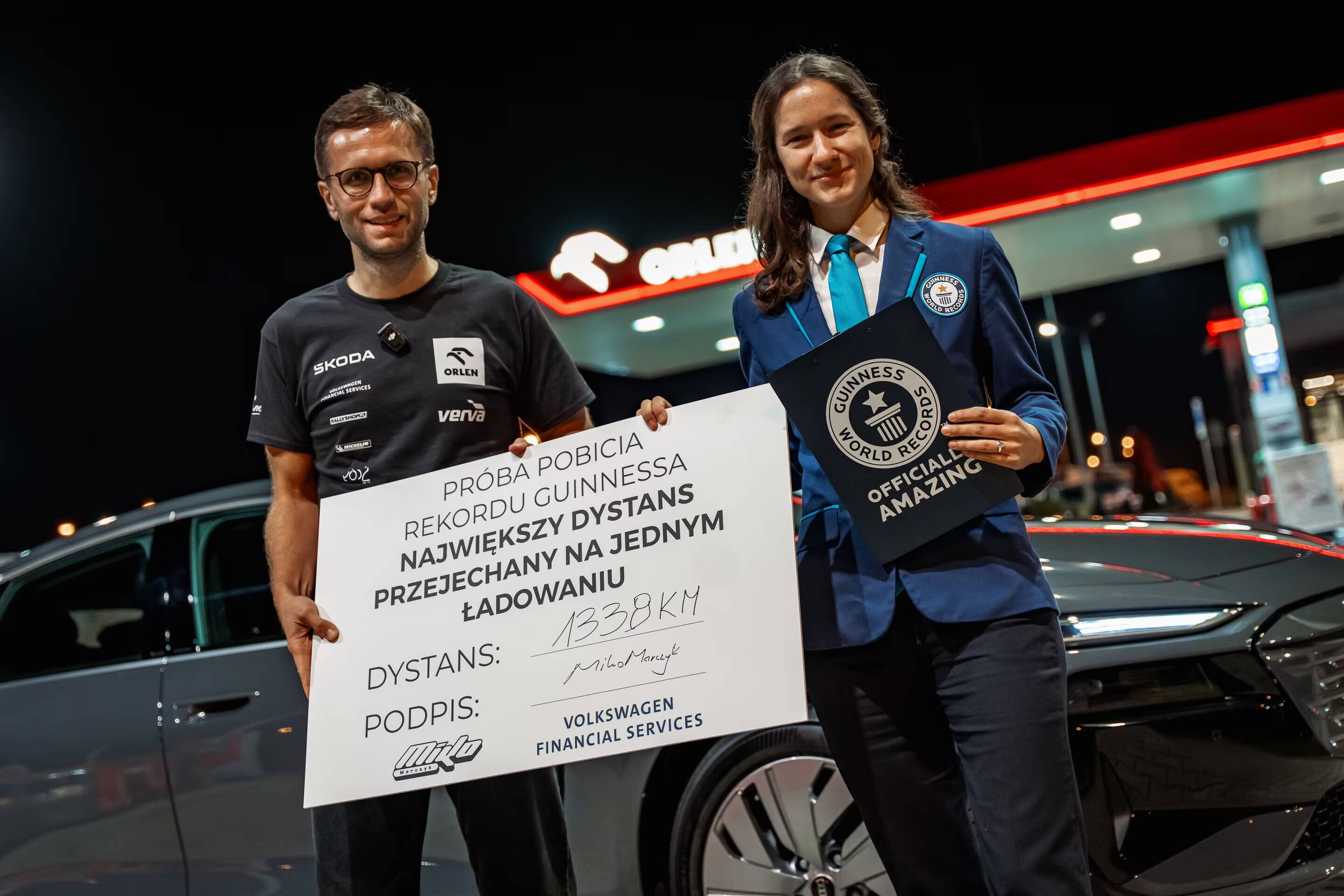Два человека держат сертификат рекорда Audi A6 Sportback e-tron