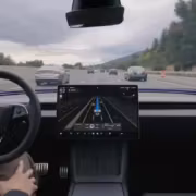Автомобиль Tesla с дисплеем автопилота на дороге