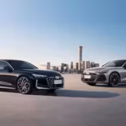 Audi A6 L из Китая добралась до России: 272 л.с. и полный привод за 7,29 млн рублей 3 Два автомобиля Audi A6 L на фоне города в небе