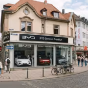 Люди проходят мимо автосалона BYD с электромобилями