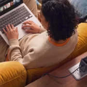 Человек с ноутбуком и зарядкой Anker PowerPort Galaxy передаёт изображение из статьи