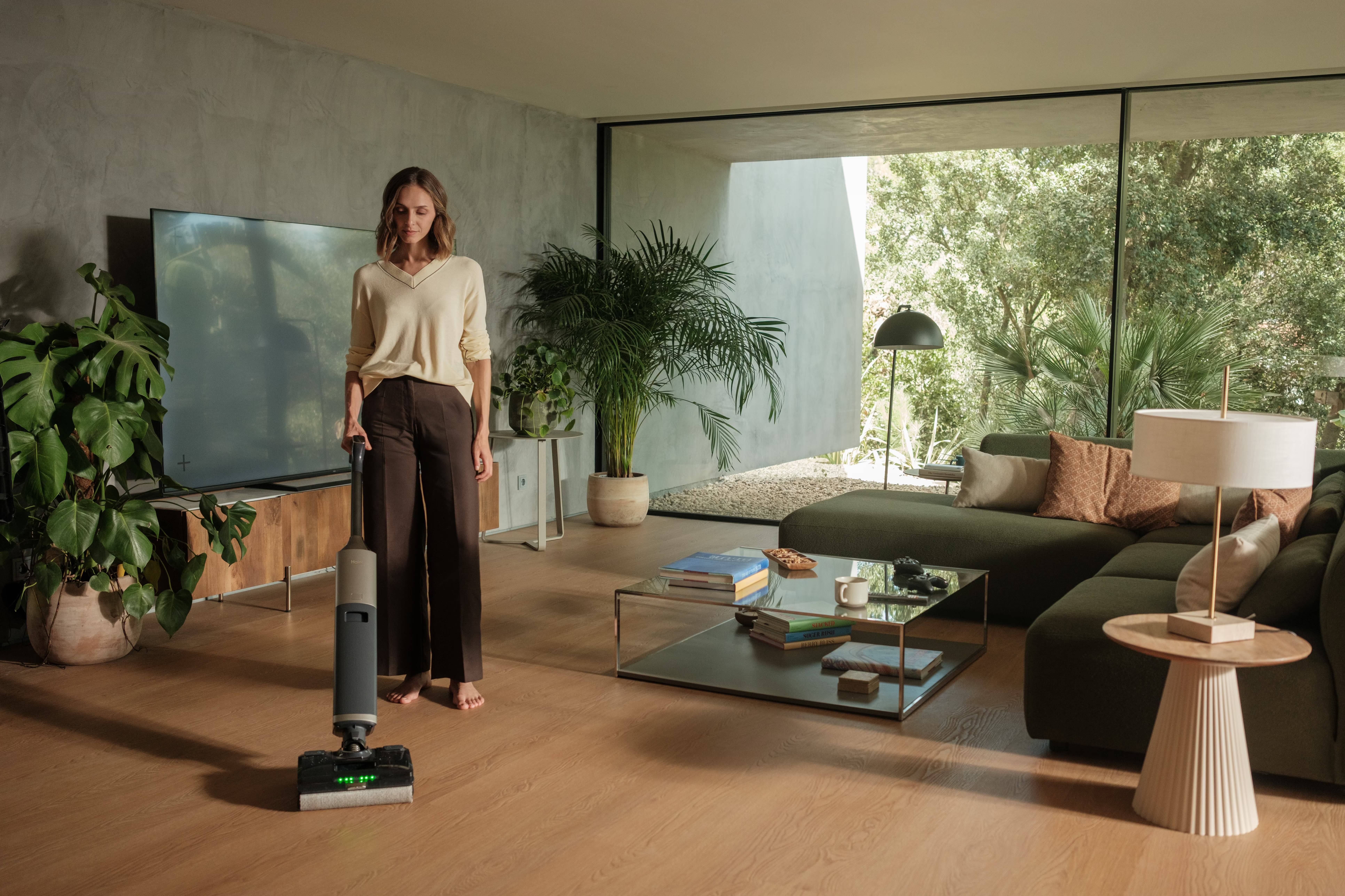 IFA 2026: Haier показала умный дом, где ИИ взялся за стирку и готовку 7 Женщина на полу в гостиной с пылесосом Haier