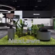 выставочный стенд NexLawn с газонокосилкой и растениями