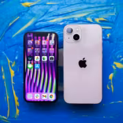 iPhone 14 и iPhone 14 Pro на фоне абстрактного синего и желтого искусства