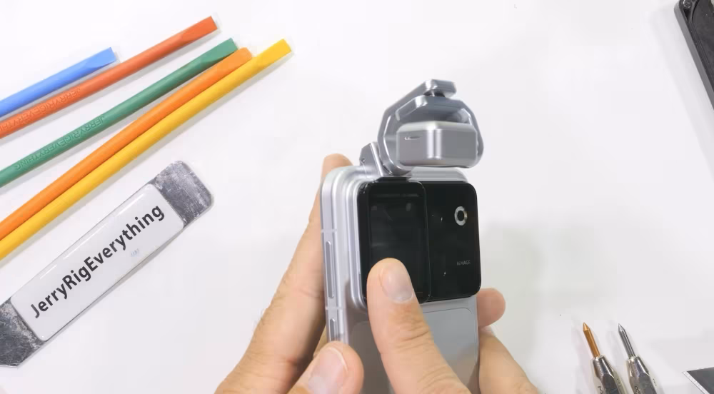 JerryRigEverything испытал смартфон Honor Robot Phone с помощью песка и разобрал его 11 Рука держит смартфон Honor Robot Phone открытый крышкой
