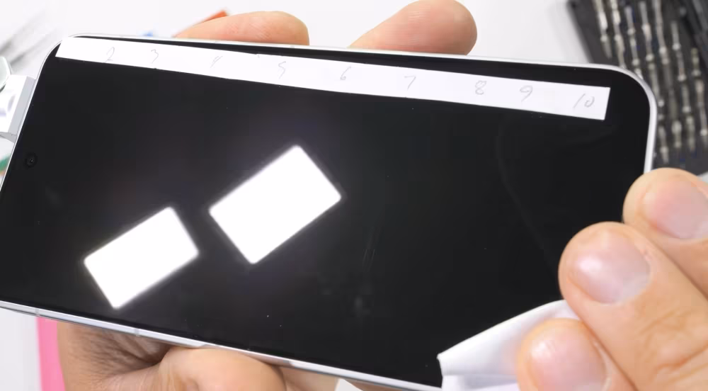 JerryRigEverything испытал смартфон Honor Robot Phone с помощью песка и разобрал его 13 Рука держит смартфон Honor Robot Phone с защитной пленкой