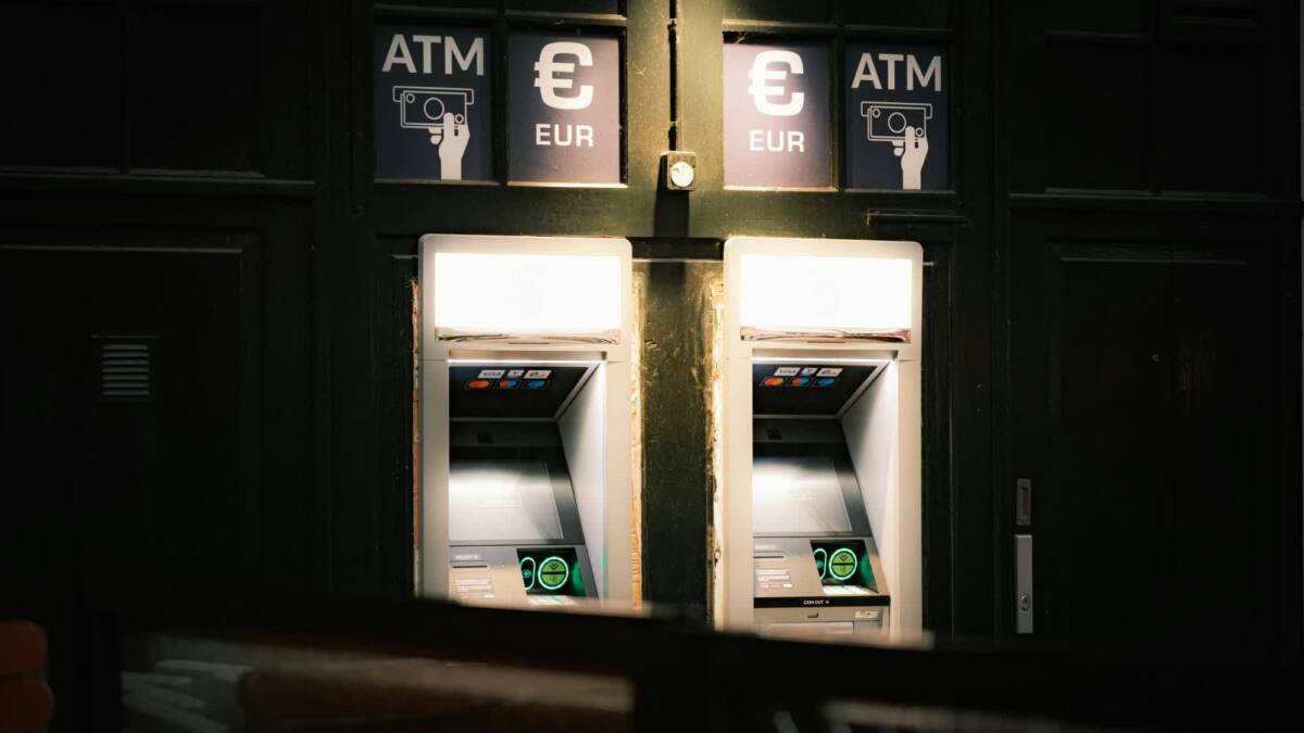 Два банкомата с логотипами EU и ATM в темноте