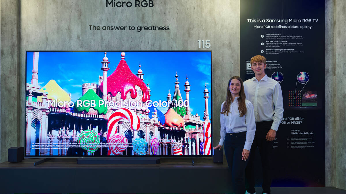 Двое молодых людей возле телевизора Samsung Micro RGB TV