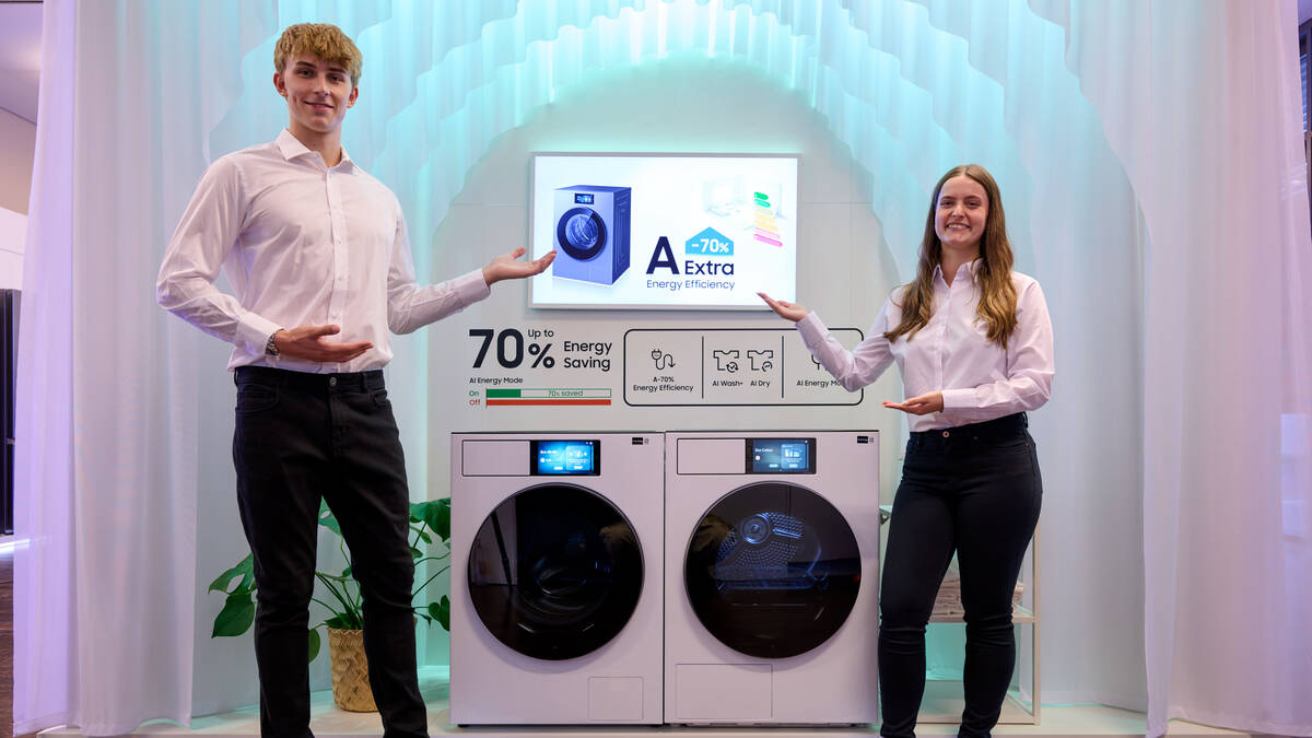 Два человека показывают стиральную машину Samsung AI Living