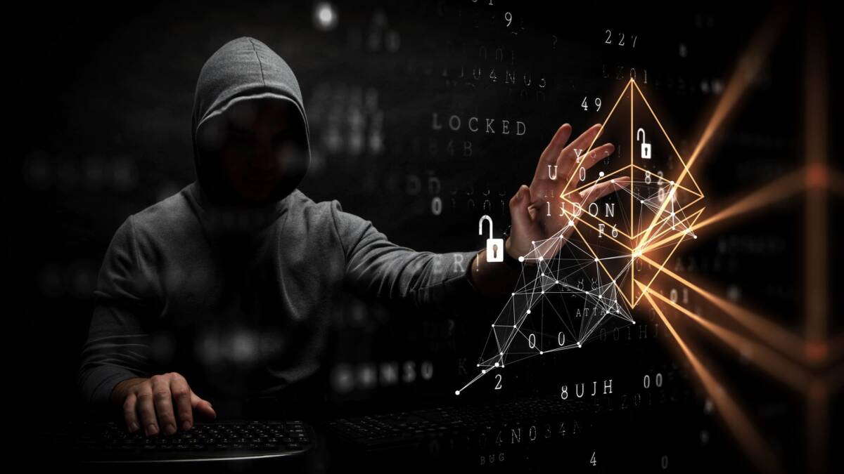 Хакер в капюшоне использует компьютер для взлома Bitget