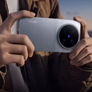Человек держит смартфон vivo X500 с круглыми камерными модулями