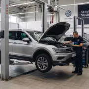 Механик проверяет Volkswagen Tiguan в автосервисе отзывы Volkswagen