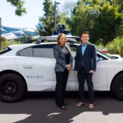 Двое человек возле автомобиля Waymo беспилотное такси