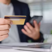 Человек держит кредитную карту и смартфон в руке