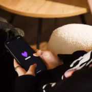 Человек держит смартфон с логотипом Deezer