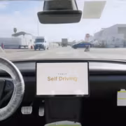 экран Tesla Self Driving на приборной панели автомобиля
