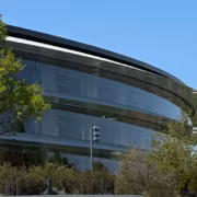 Apple оспаривает вердикт на $5,7 млрд, а Taction требует новых выплат 2 Современное стеклянное здание с изгибающейся крышей