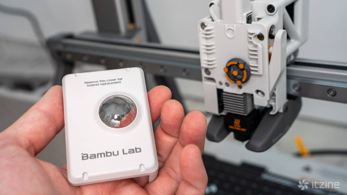 Обзор Bambu Lab A2L Combo + модуль резки: большой 3D-принтер с необычными возможностями 67 Рука держит устройство Bambu Lab A2L Combo вблизи 3D-принтера