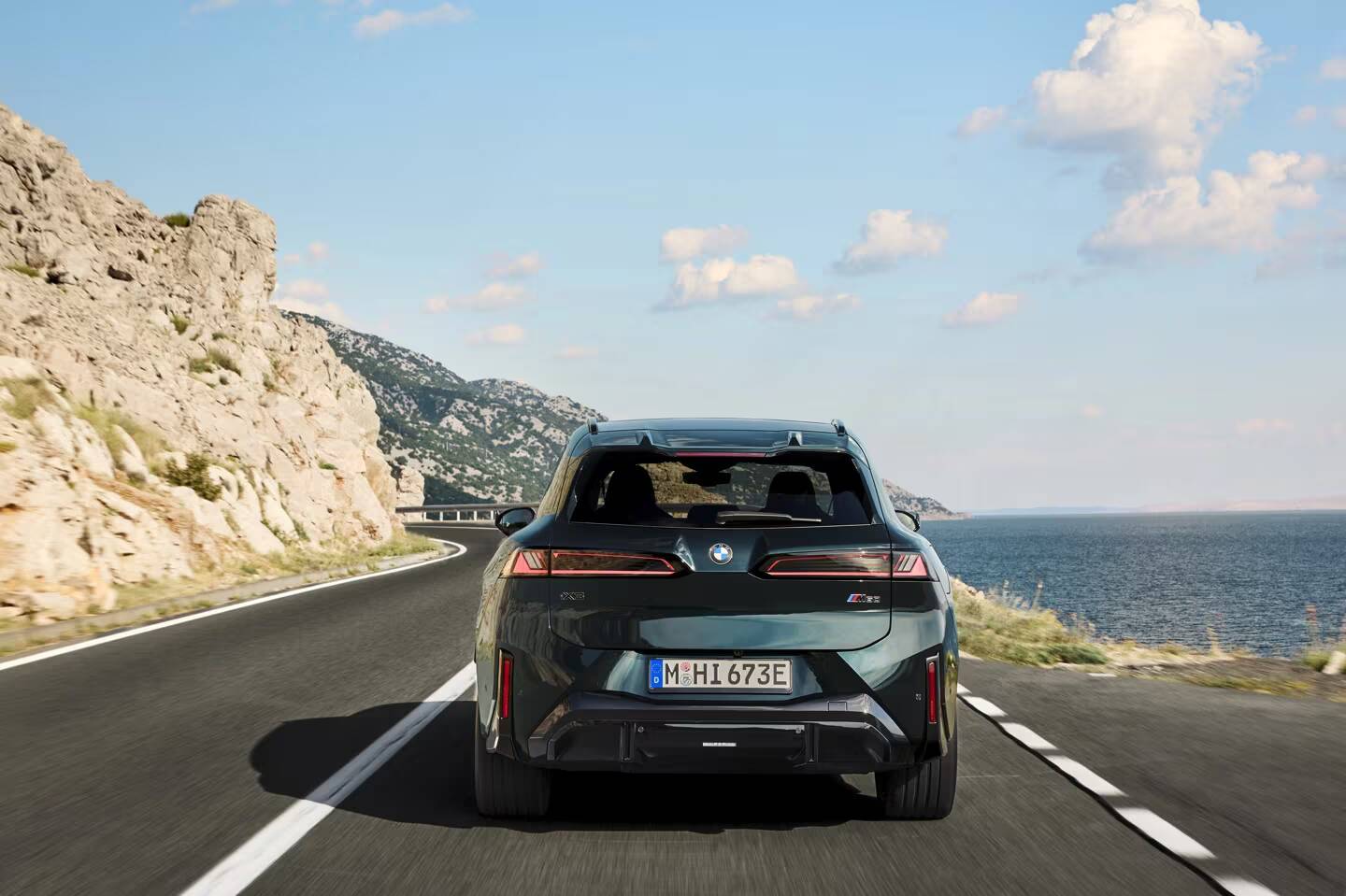 BMW представила iX3 M60 с разгоном до 100 км/ч за 3,9 секунды 1 Черный кроссовер BMW iX3 M60 на дороге у моря