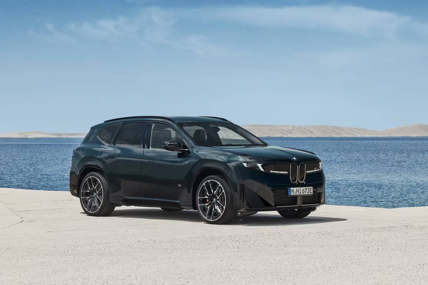 BMW представила iX3 M60 с разгоном до 100 км/ч за 3,9 секунды 2 Черный электромобиль BMW iX3 M60 на песке солнечной пляжной полосы