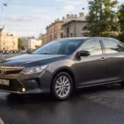 Черный седан Toyota Camry на городской улице