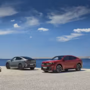 Два электрокроссовера BMW iX4 на фоне моря и неба